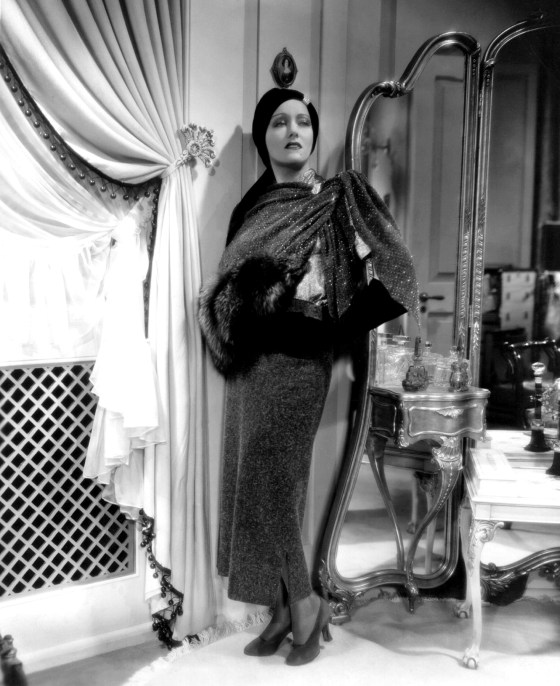 1934: Gloria Swanson (1897 - 1983) models one of the many gowns, designed and created by Rume Hubert for her role in the film 'Music In The Air', directed by Joe May for Fox.
