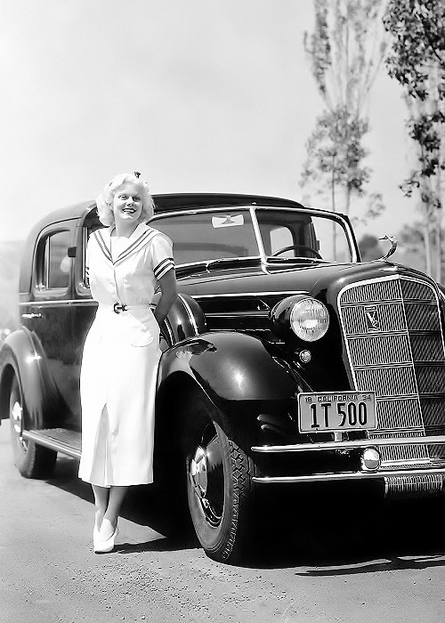 Jean Harlow poses with her Cadillac limousine, 1934