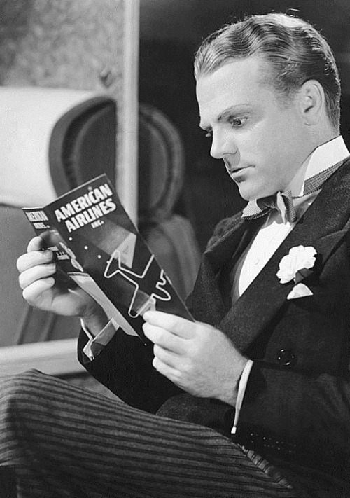 James Cagney reads an American Airlines safety brochure during a flight